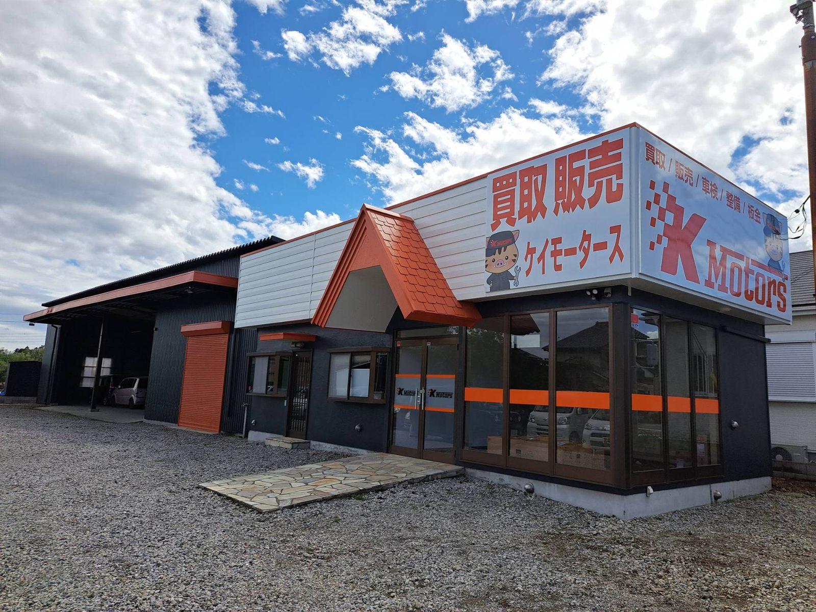 ケイモータースの店舗外観。オレンジの屋根と「買取 販売」の看板